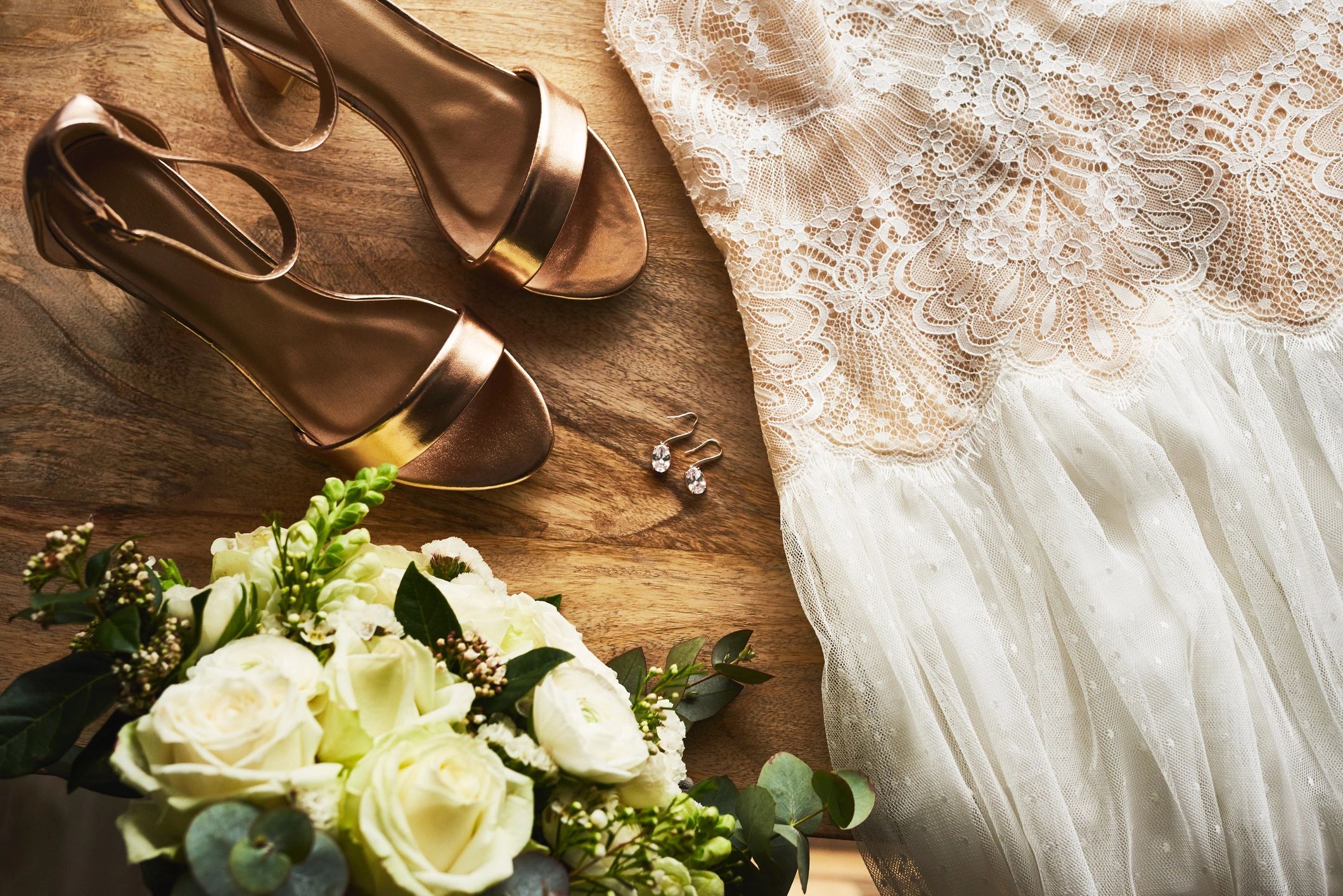 Wedding details flat lay with bouquet and dress