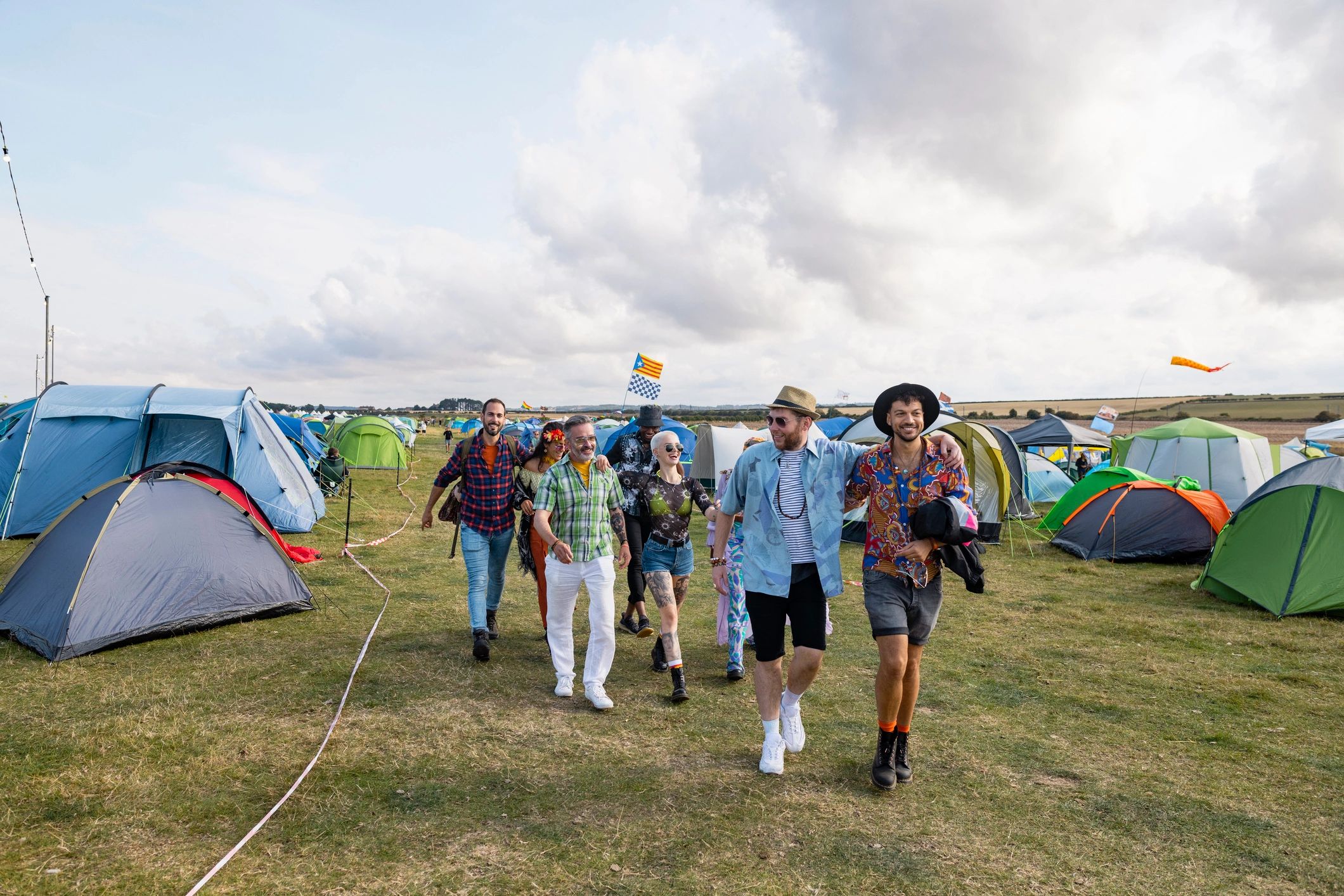 Festival goers walking and laughing in a field