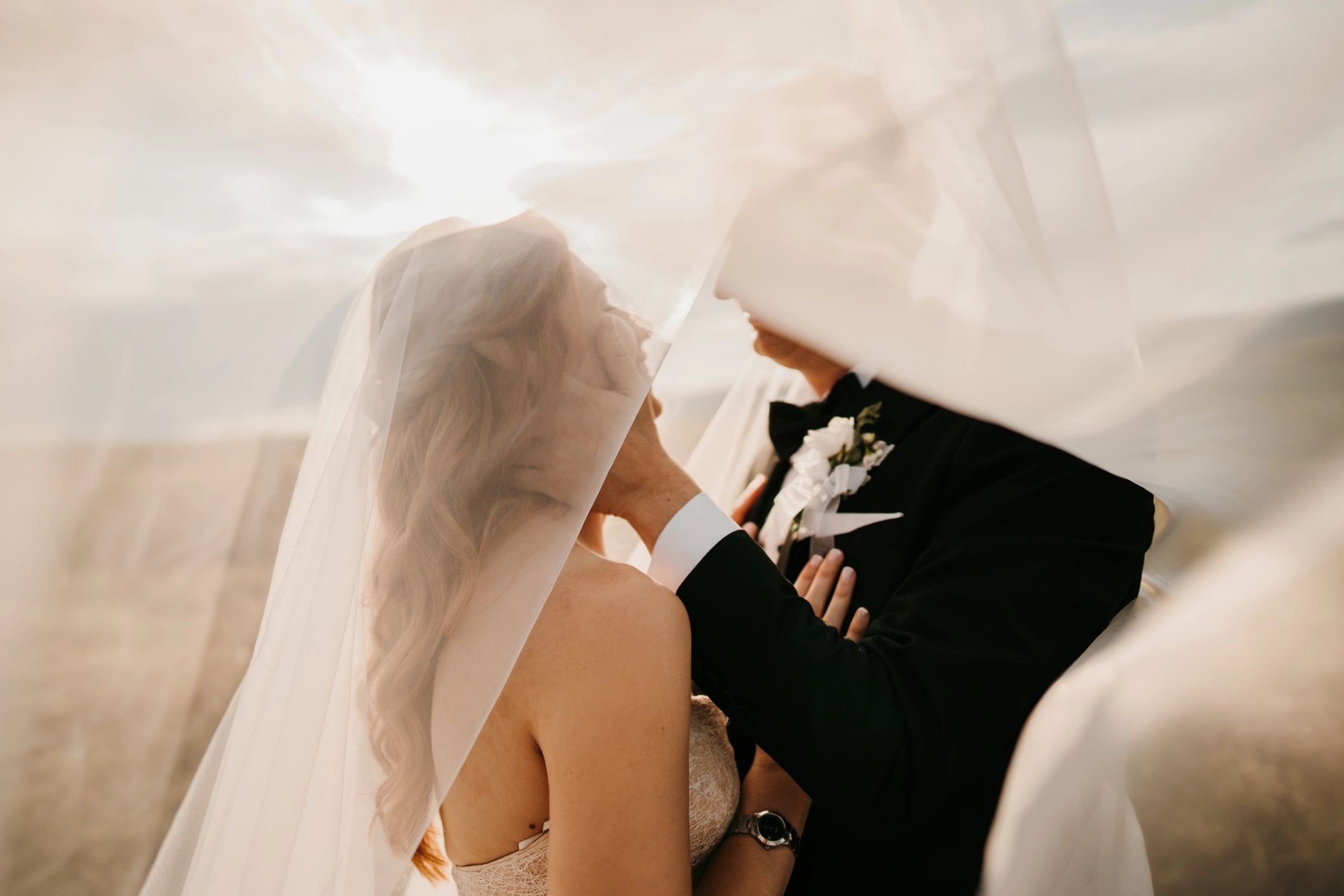 Bride and groom under a veil in nature