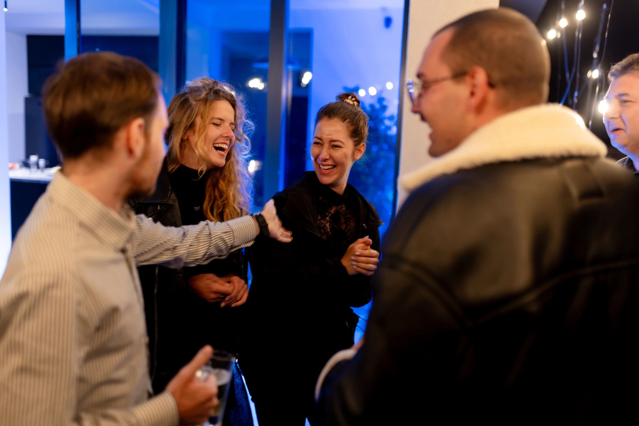 Friends laughing together at an indoor social event
