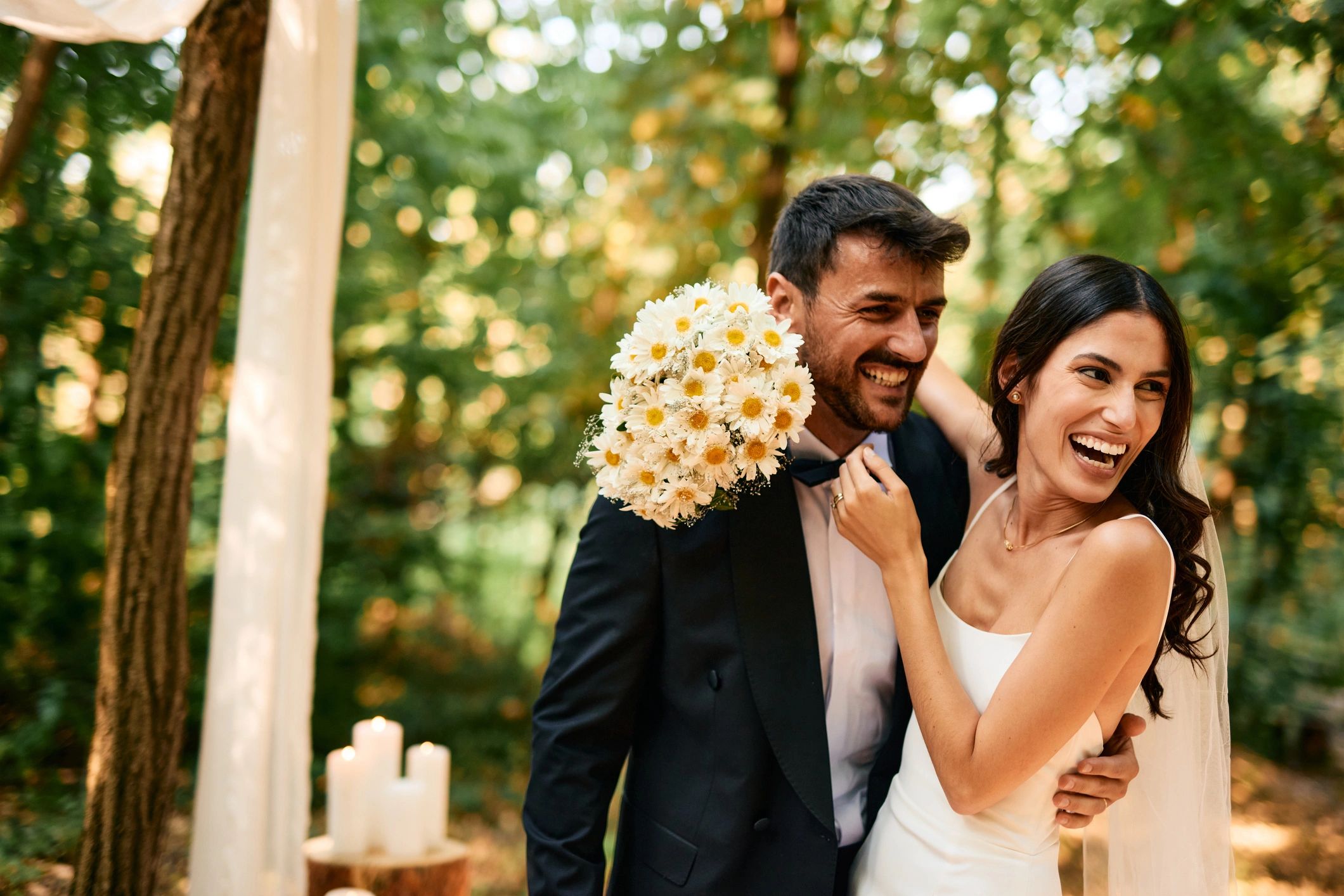 Newlyweds laughing and hugging outdoors