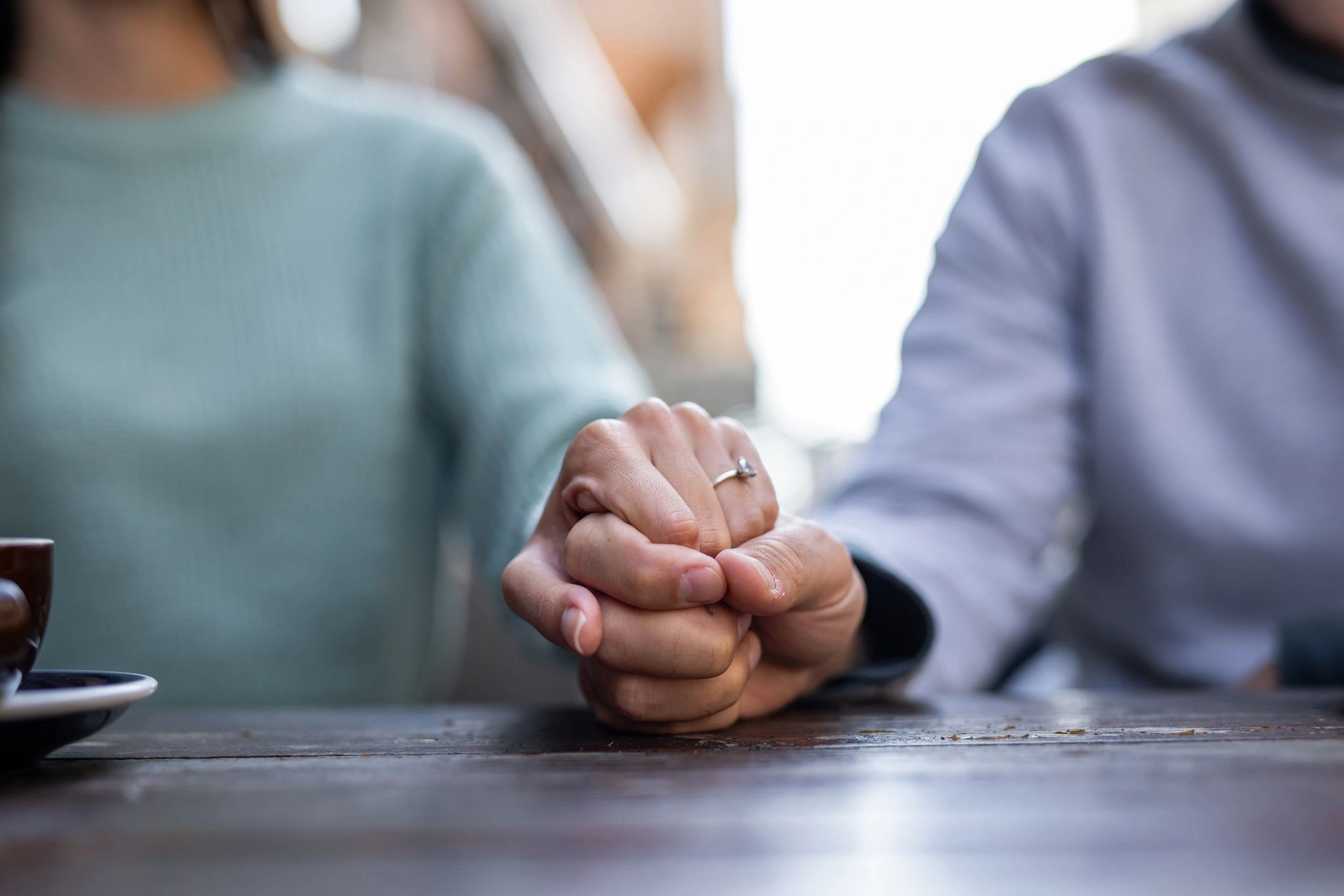 Couple holding hands with ring visible